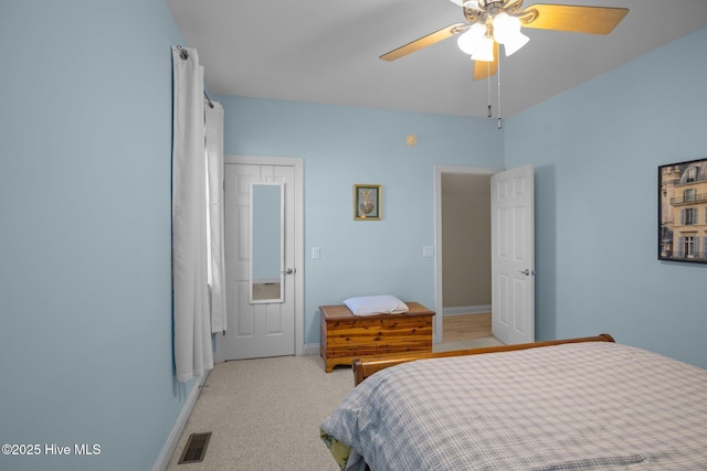 bedroom featuring baseboards, a ceiling fan, visible vents, and light colored carpet