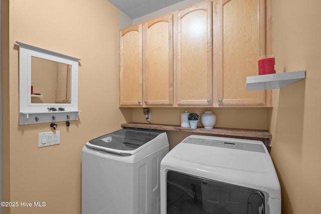 washroom featuring cabinet space and independent washer and dryer