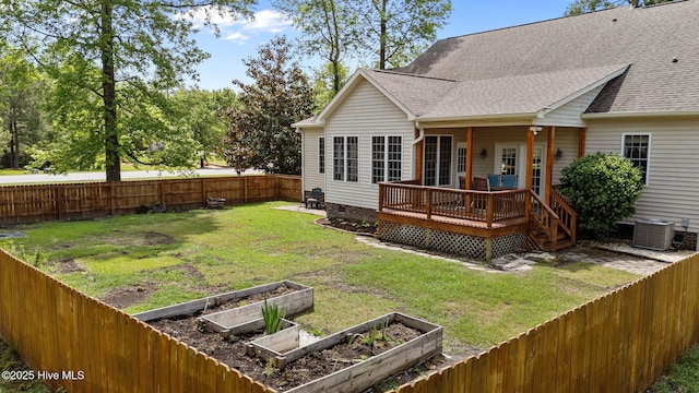 back of house with a garden, a shingled roof, a fenced backyard, and central AC unit