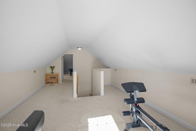 exercise area with vaulted ceiling and carpet