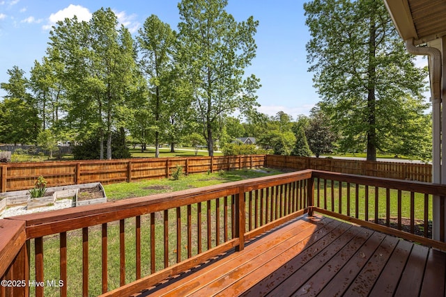 wooden deck with a fenced backyard, a vegetable garden, and a lawn
