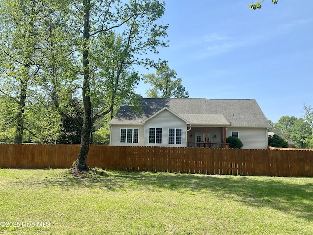 back of house featuring fence and a yard