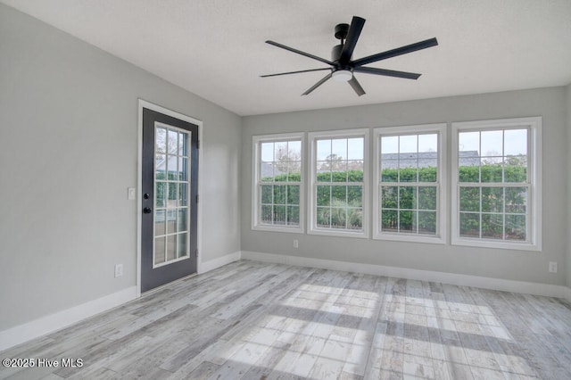 unfurnished sunroom featuring ceiling fan