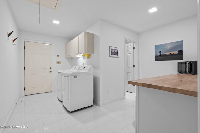 laundry room featuring cabinets, washing machine and dryer, and light tile patterned floors