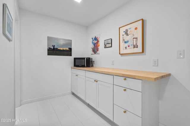 bar with white cabinetry and butcher block counters