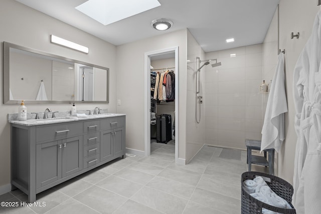 bathroom featuring vanity, tiled shower, tile patterned floors, and a skylight