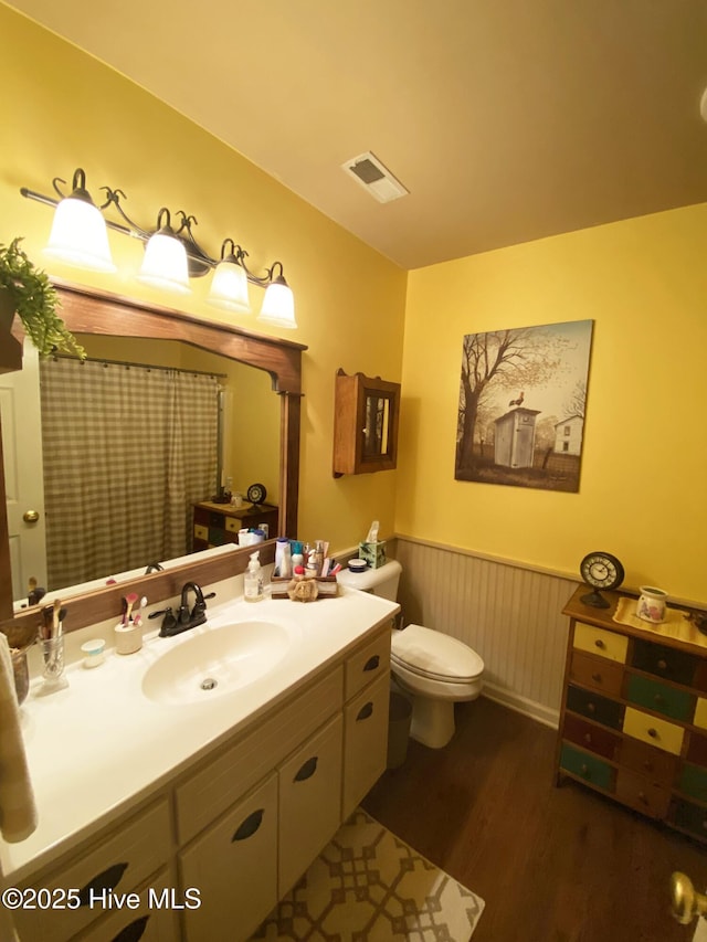 bathroom featuring vanity, hardwood / wood-style flooring, and toilet