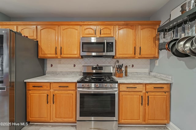 kitchen with stainless steel appliances and decorative backsplash