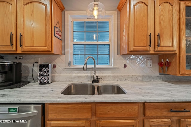 kitchen with light stone counters, sink, backsplash, and dishwasher