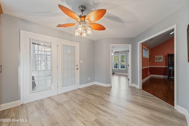 empty room featuring ceiling fan, light hardwood / wood-style floors, and lofted ceiling