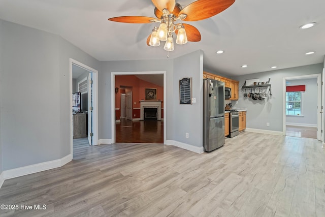 kitchen with light hardwood / wood-style floors, ceiling fan, and appliances with stainless steel finishes