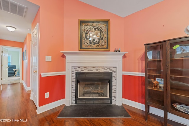 living room featuring hardwood / wood-style floors, a fireplace, and lofted ceiling