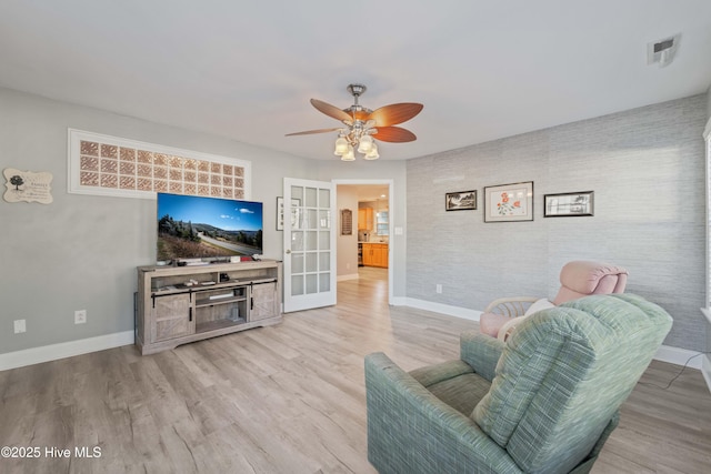 living room featuring ceiling fan and light hardwood / wood-style flooring