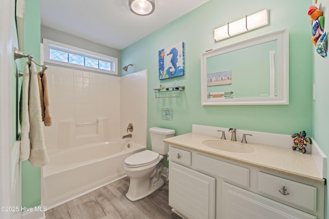 full bathroom featuring toilet, hardwood / wood-style flooring, washtub / shower combination, and vanity