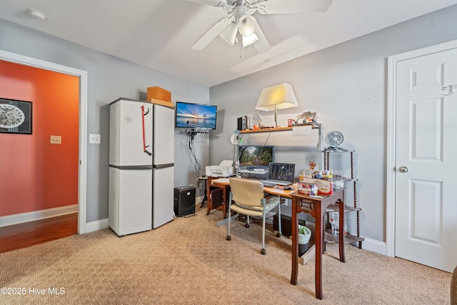 carpeted office space featuring ceiling fan