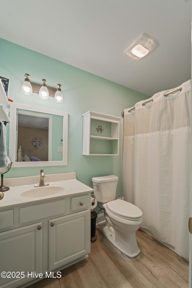 bathroom featuring hardwood / wood-style floors, toilet, vanity, and a shower with shower curtain