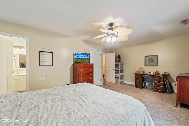 bedroom featuring ceiling fan, sink, light colored carpet, and ensuite bathroom