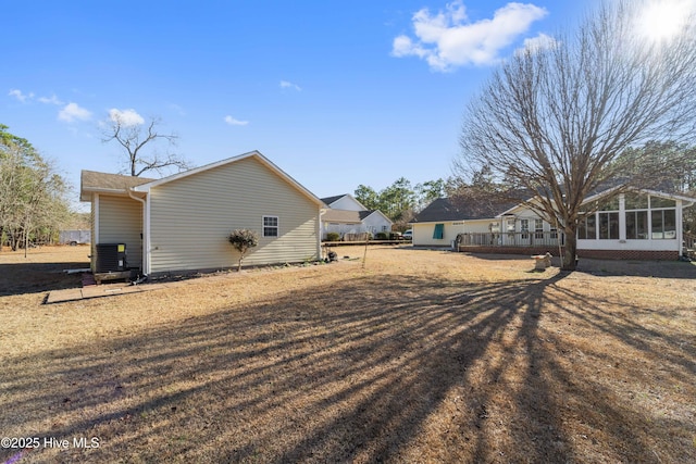 view of side of home with a lawn and a sunroom