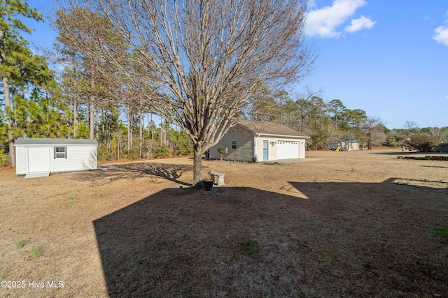 view of yard with a garage and a storage shed