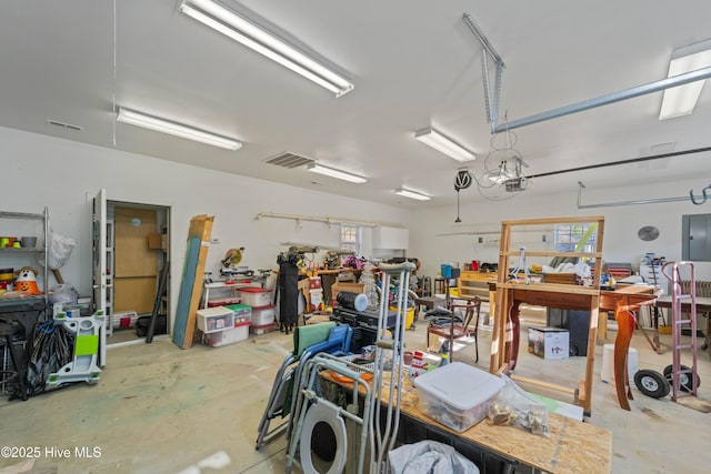 garage featuring a garage door opener, electric panel, and a workshop area