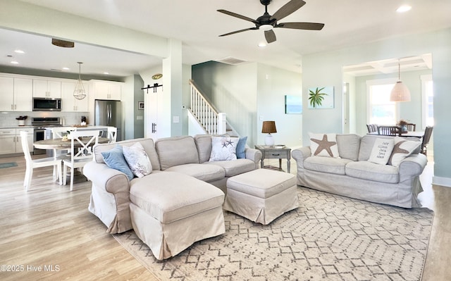 living room featuring ceiling fan and light hardwood / wood-style flooring