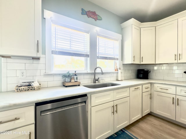 kitchen featuring white cabinetry, sink, backsplash, and dishwasher