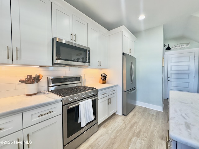 kitchen featuring tasteful backsplash, white cabinetry, appliances with stainless steel finishes, and light hardwood / wood-style flooring