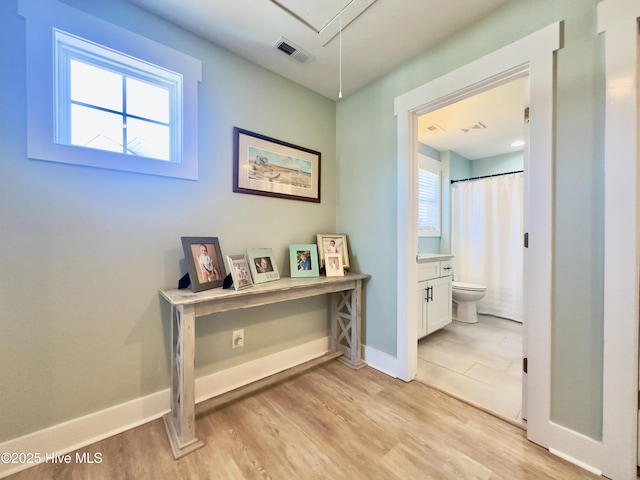 hallway with a healthy amount of sunlight and light hardwood / wood-style floors