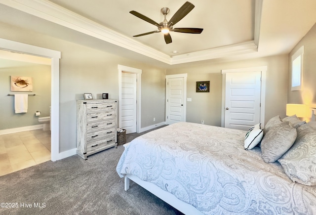 bedroom with ensuite bath, ornamental molding, a raised ceiling, and carpet