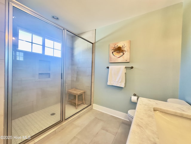 bathroom featuring a shower with door and toilet