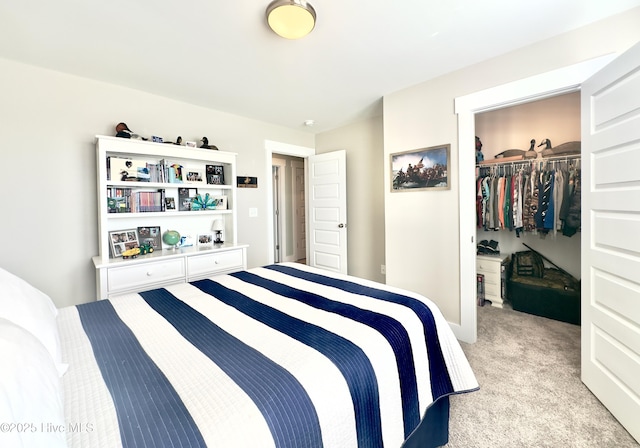 bedroom with a walk in closet, light carpet, and a closet