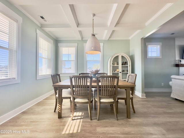 dining space with beamed ceiling, plenty of natural light, coffered ceiling, and light hardwood / wood-style floors