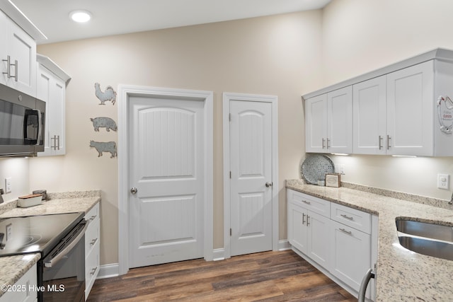 kitchen with light stone counters, white cabinetry, and range with electric cooktop