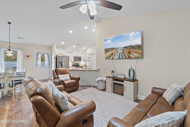 62 NE Dr NW, Calabash, NC 28467 - living room featuring vaulted ceiling, wood finished floors, a ceiling fan, recessed lighting, and baseboards