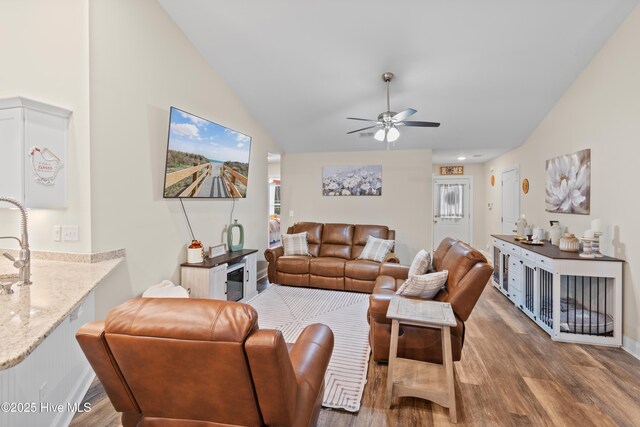 62 NE Dr NW, Calabash, NC 28467 - living area featuring wood finished floors, vaulted ceiling, a ceiling fan, and baseboards