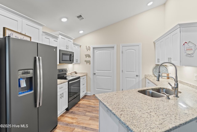 62 NE Dr NW, Calabash, NC 28467 - kitchen with stainless steel appliances, a sink, lofted ceiling, a peninsula, and light stone counters