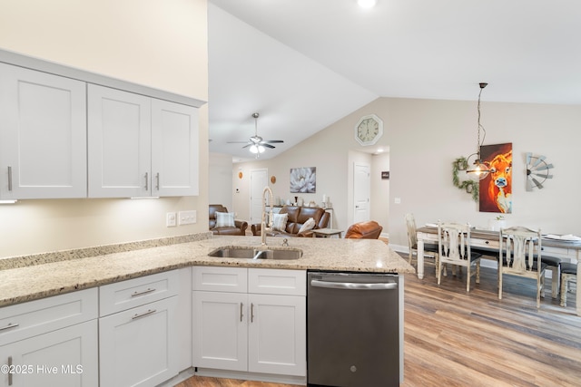 62 NE Dr NW, Calabash, NC 28467 - kitchen with stainless steel dishwasher, a sink, a peninsula, lofted ceiling, and light wood-style flooring