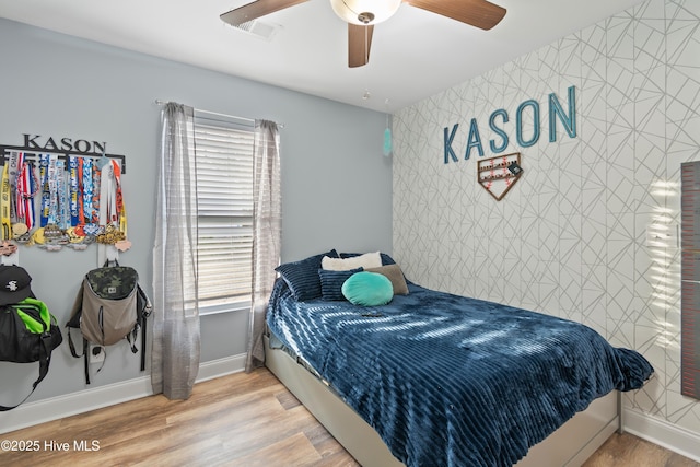 62 NE Dr NW, Calabash, NC 28467 - bedroom with baseboards, an accent wall, ceiling fan, and wood finished floors