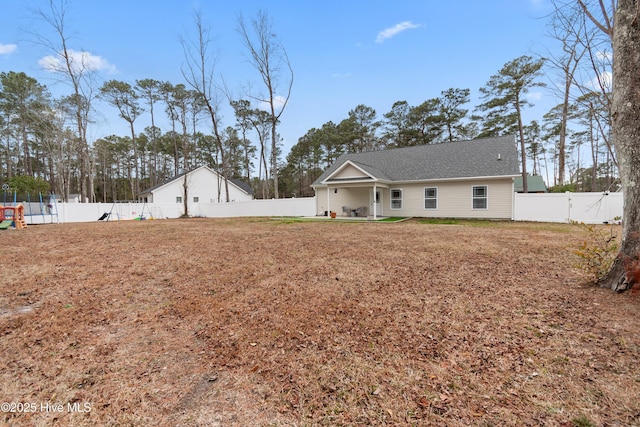 rear view of property featuring a patio area and a yard