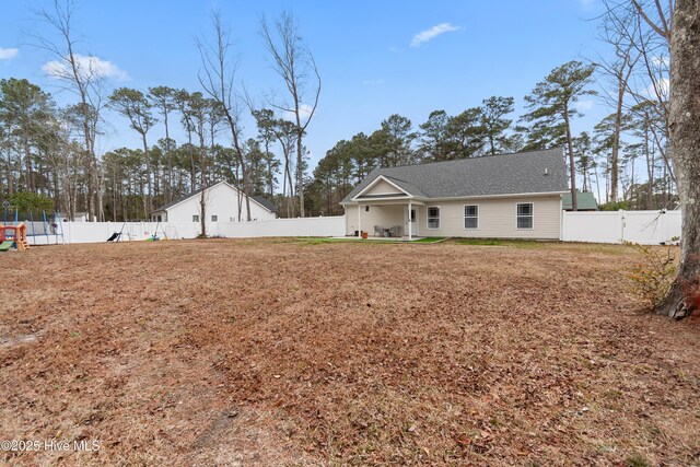 62 NE Dr NW, Calabash, NC 28467 - back of property featuring a fenced backyard, a patio, and roof with shingles