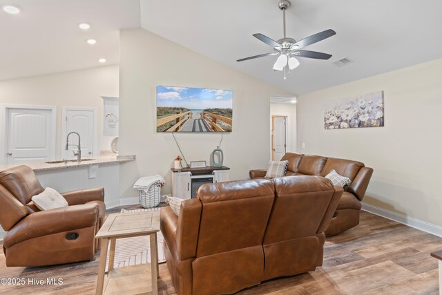 living room featuring hardwood / wood-style flooring, ceiling fan, and lofted ceiling