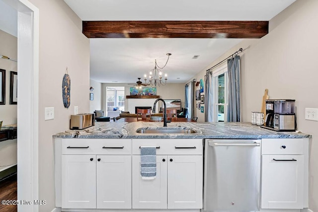 kitchen with dishwasher, white cabinetry, beamed ceiling, a fireplace, and sink