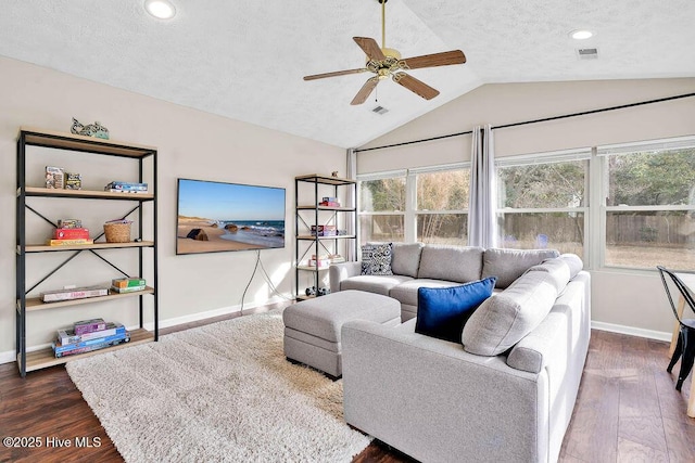 living room with vaulted ceiling, ceiling fan, dark wood-type flooring, and plenty of natural light