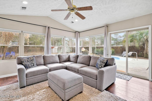 sunroom with ceiling fan, vaulted ceiling, and a healthy amount of sunlight