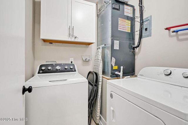 clothes washing area with washing machine and clothes dryer, heating unit, and cabinets