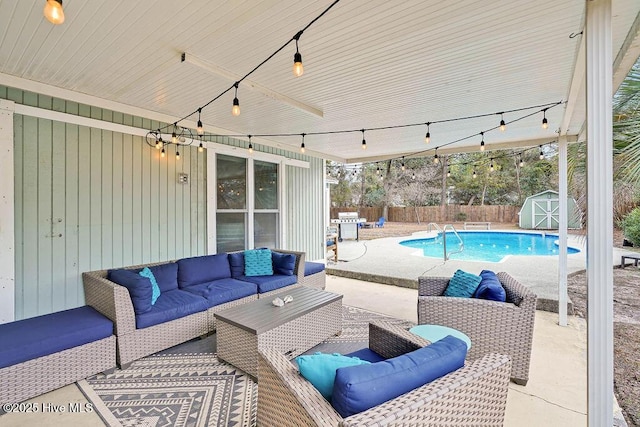 view of patio featuring an outdoor living space, a fenced in pool, and a storage shed