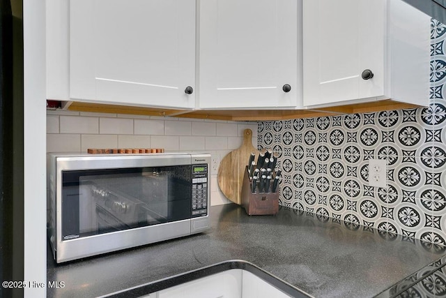 details with decorative backsplash and white cabinetry