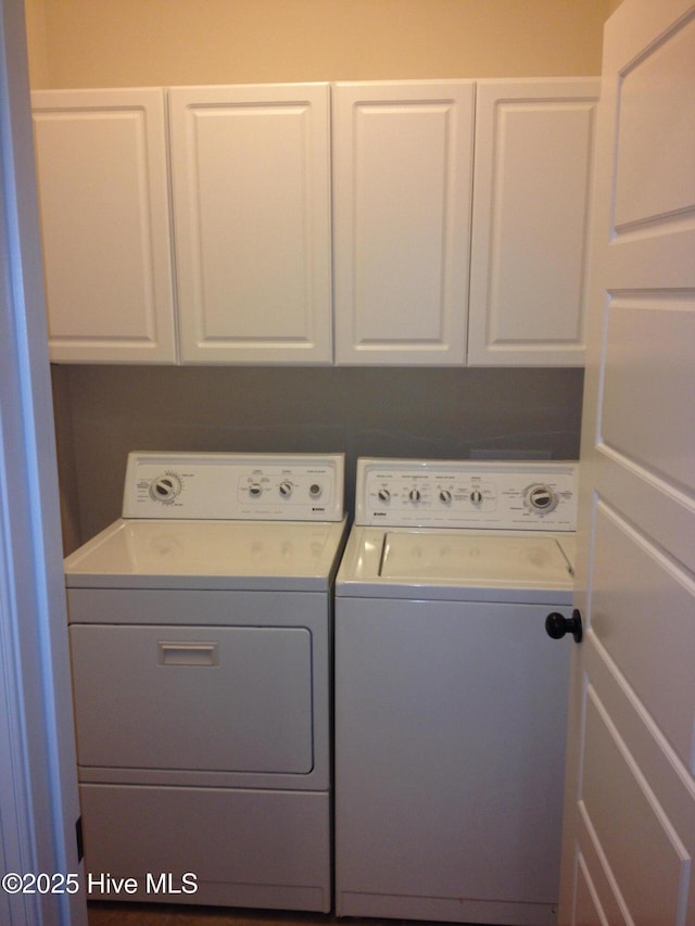 clothes washing area with cabinets and washer and dryer