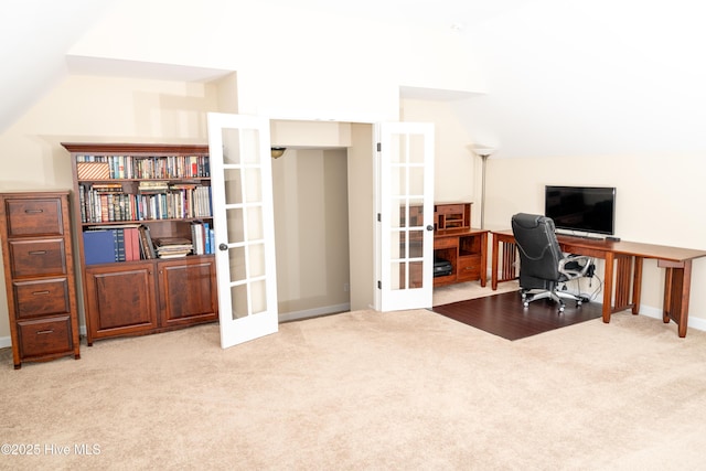 carpeted office space featuring french doors and vaulted ceiling