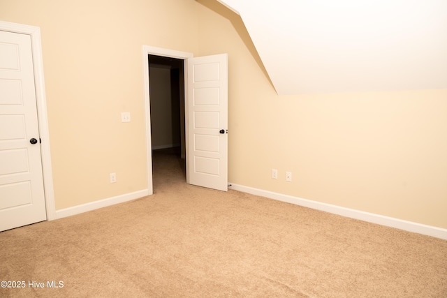 additional living space featuring light colored carpet and lofted ceiling